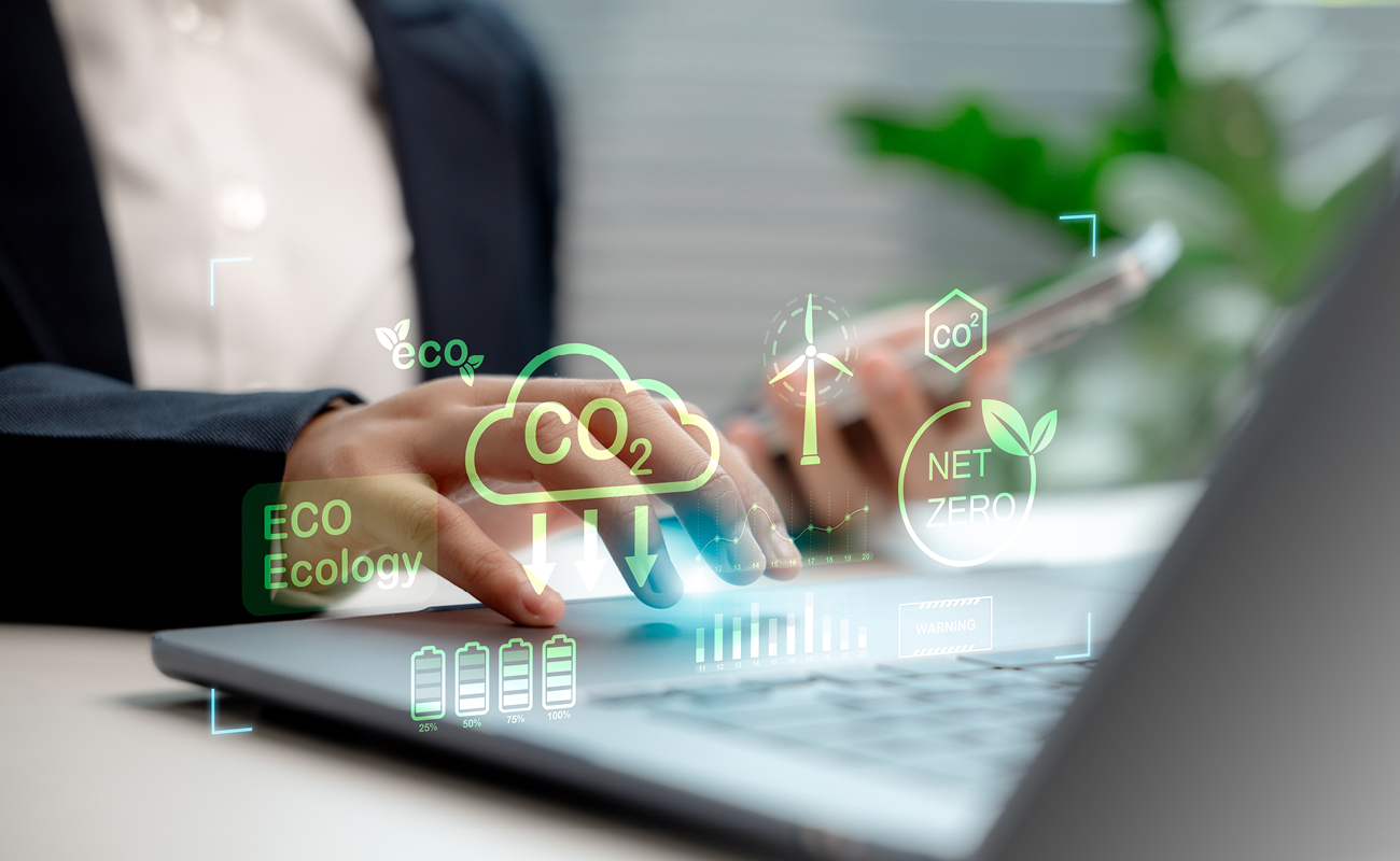 Frauenhand mit Laptop, darüber liegen Icons, die die CO2-Reduktion symbolisieren